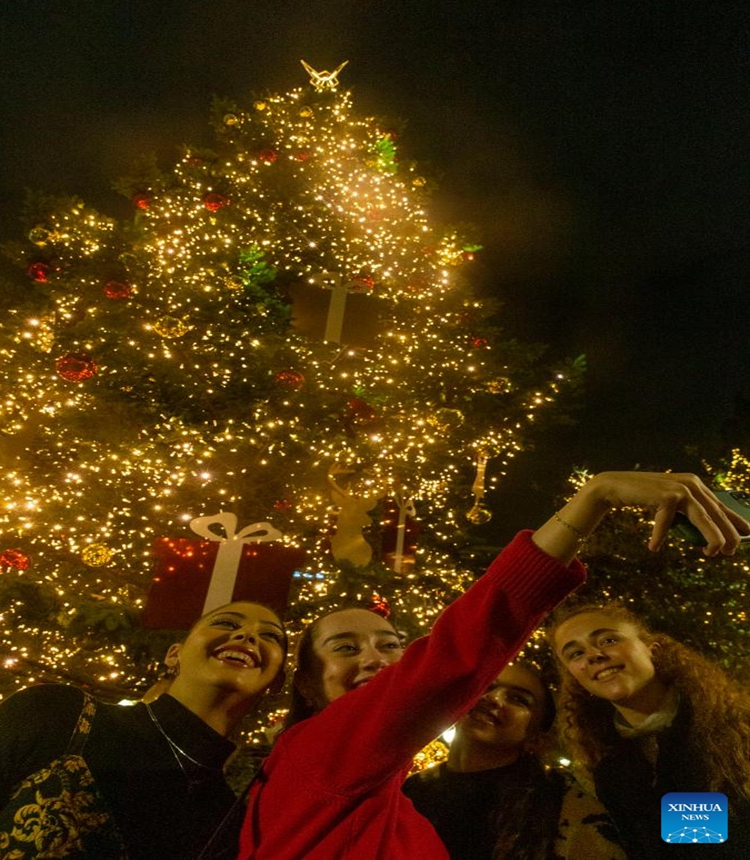 A girl takes a selfie with an illuminated Christmas tree at Syntagma Square in Athens, Greece, on Nov. 23, 2023. The holiday season kicked off in Athens with a tree lighting ceremony on Thursday. (Photo: Xinhua)