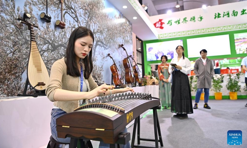 A girl plays guzheng, a traditional Chinese plucked zither, during the first World Forestry Industry Conference at Nanning International Convention and Exhibition Center in Nanning, capital of south China's Guangxi Zhuang Autonomous Region, Nov. 25, 2023. The first World Forestry Industry Conference opened in Nanning on Saturday. The event includes a combination of conferences, exhibitions and forums. (Photo: Xinhua)