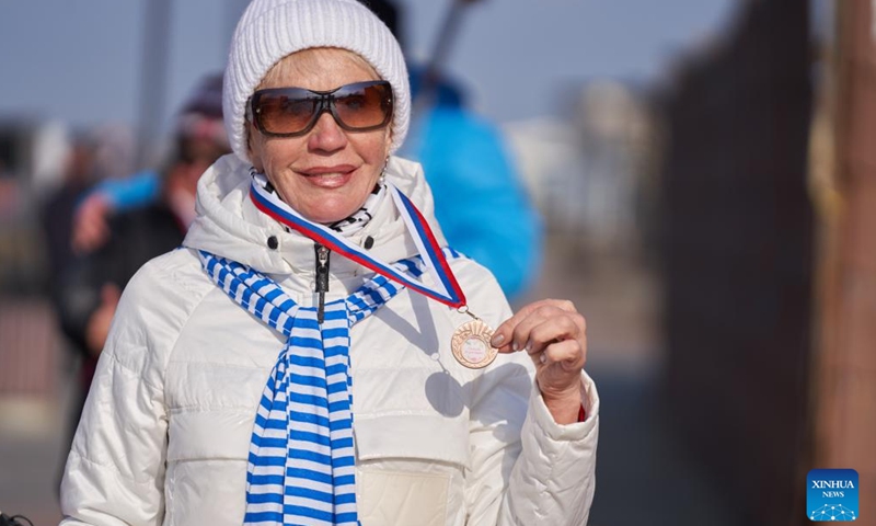 A woman shows her medal after completing the Nordic walking race in Vladivostok, Russia, Nov. 26, 2023. A Nordic walking race was held in the Russian Far East city of Vladivostok to commemorate the Mother's Day of the country, which falls on the last Sunday of November. (Photo: Xinhua)