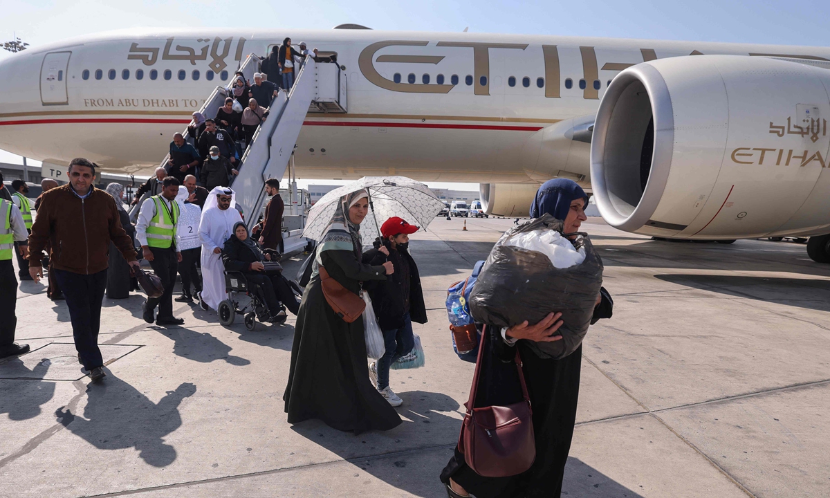 Palestinians evacuated from the Gaza Strip who arrived on a plane from Egypt's El-Arish airport disembark upon landing in Abu Dhabi on November 27, 2023, as part of a humanitarian mission. Photo: VCG