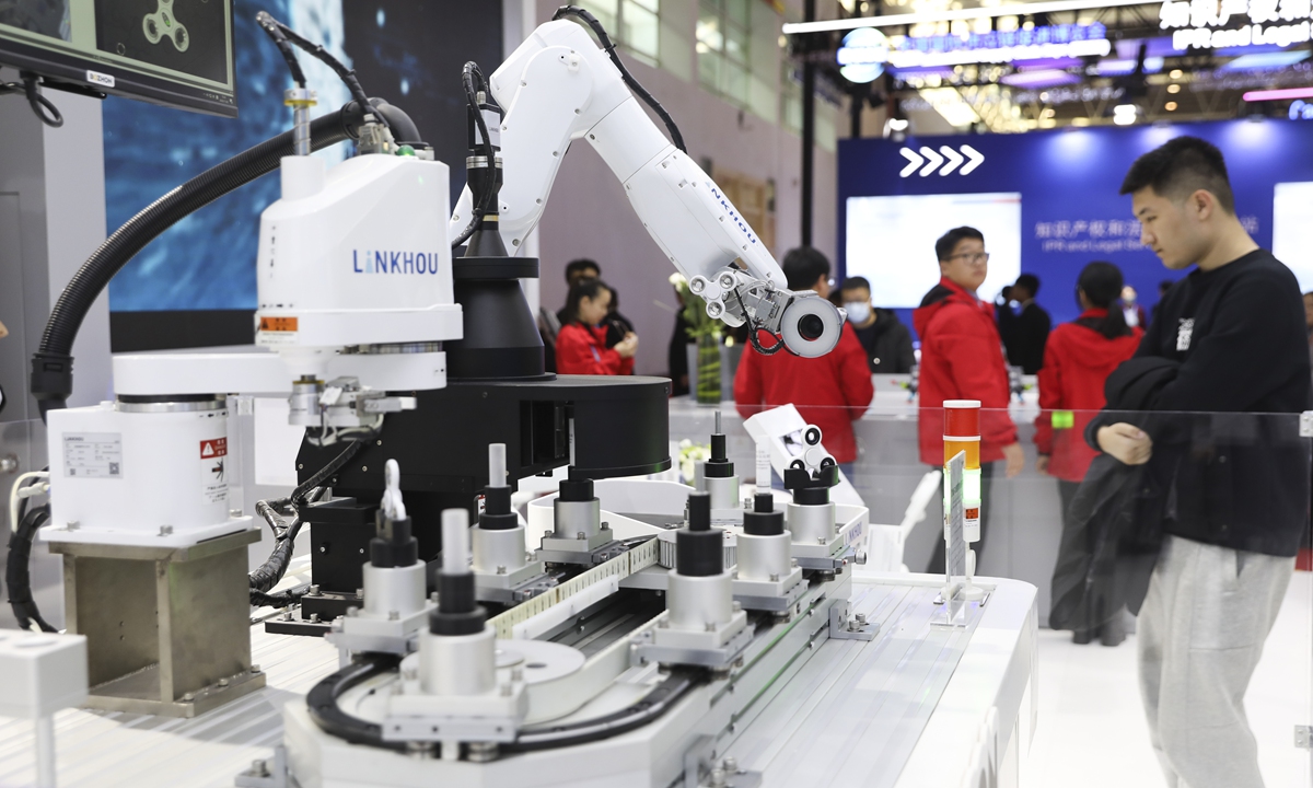 A visitor looks at a robot arm displayed at the first China International Supply Chain Expo (CISCE), which kicked off in Beijing on November 28, 2023. Among the exhibitors, 26 percent are international companies, with 36 percent of that group coming from Europe and the US. Global companies from more than 50 countries and regions are participating in the event. Photo: VCG