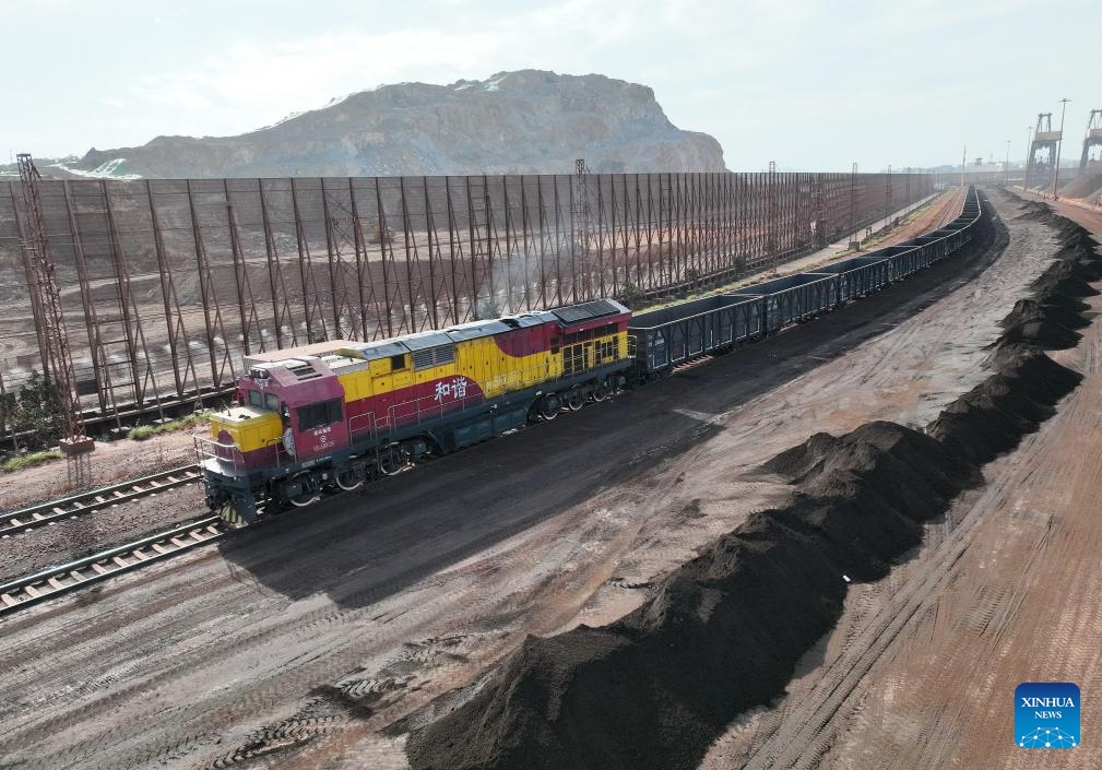 This aerial photo taken on Nov. 29, 2023 shows a sea-rail intermodal train transporting iron ore at the Luoyu operating area in Meizhou Bay of Putian City, southeast China's Fujian Province. Ports constitute an important economic activity in coastal province Fujian, a core area in the construction of the 21st Century Maritime Silk Road. Fujian has seen improving ability in serving the Belt and Road (B&R) Initiative.(Photo: Xinhua)