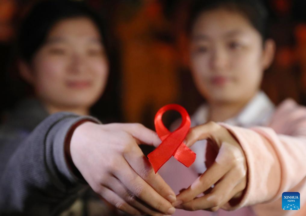 Students show a red ribbon during an event to raise awareness of AIDS at University of South China in Hengyang, central China's Hunan Province, Nov. 29, 2023. The World AIDS Day falls on Dec. 1.(Photo: Xinhua)