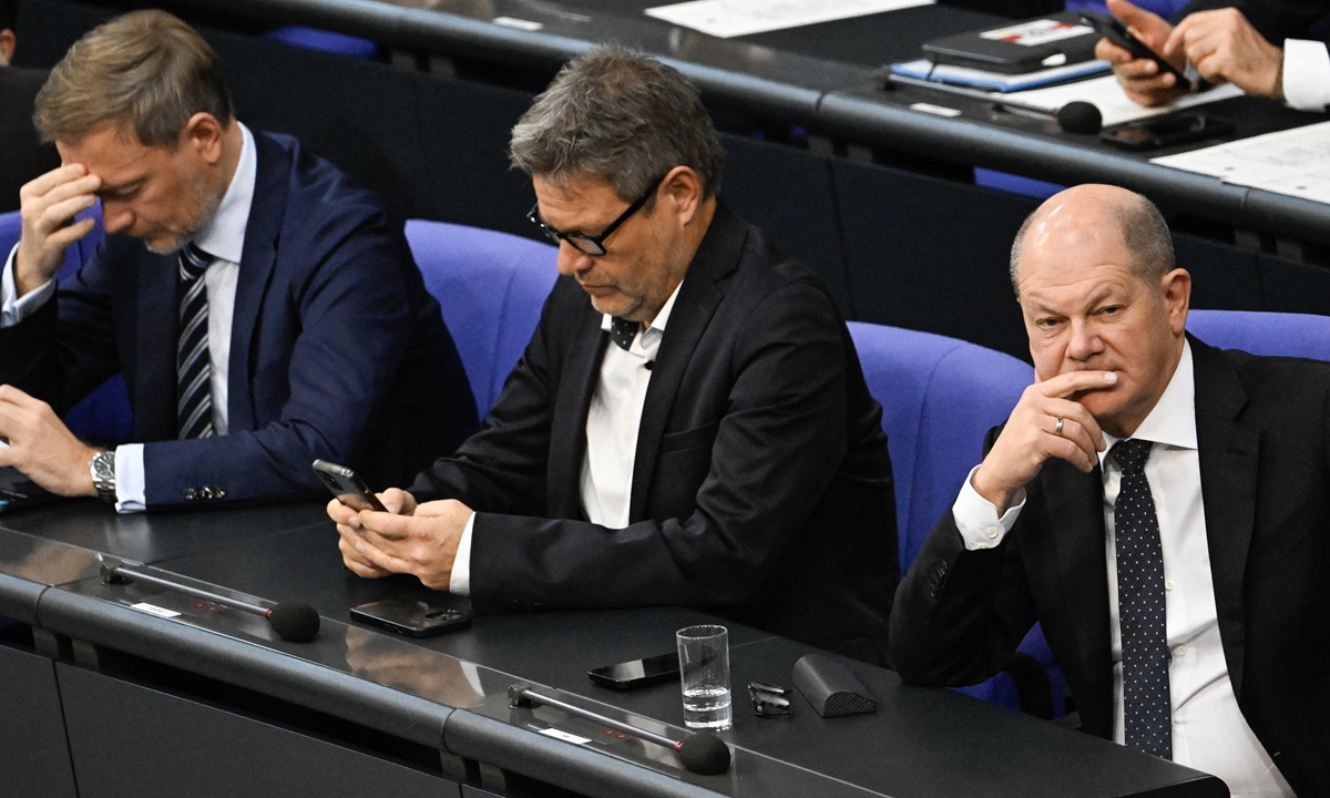 German Chancellor Olaf Scholz (right,) Minister of Economics and Climate Protection Robert Habeck (center) and Finance Minister Christian Lindner look on during a debate at the Bundestag about a budget crisis on November 28, 2023 in Berlin. German Chancellor Olaf Scholz vowed that his government will work 
