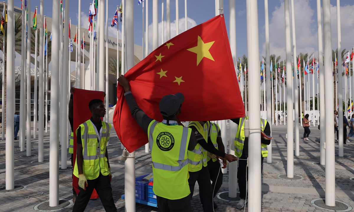 Workers get ready to hoist the national flag of China at the venue of the UNFCCC COP28 Climate Conference on November 29, 2023, the day before its official opening in Dubai, United Arab Emirates. COP28 is bringing together stakeholders, including international heads of state and other leaders, scientists, environmentalists, activists and others to discuss and agree on the implementation of global measures toward mitigating the effects of climate change. (See story on Page 4) Photo: VCG