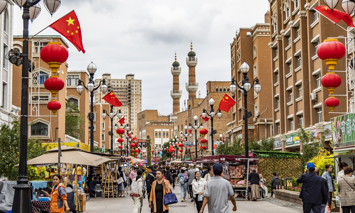 People walk on the street of the Xinjiang International Grand Bazaar in Urumqi. Phoro: VCG