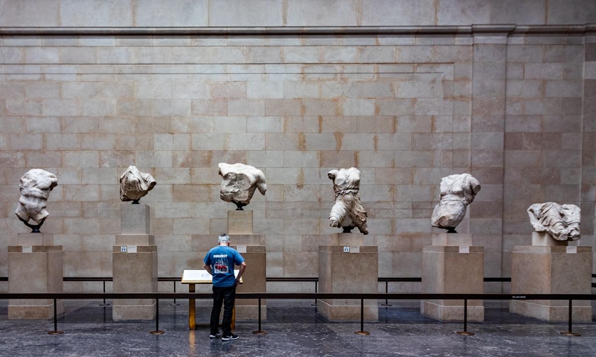 A visitor reads the description of the Parthenon Marbles at the British Museum in London, the UK. Photo: VCG