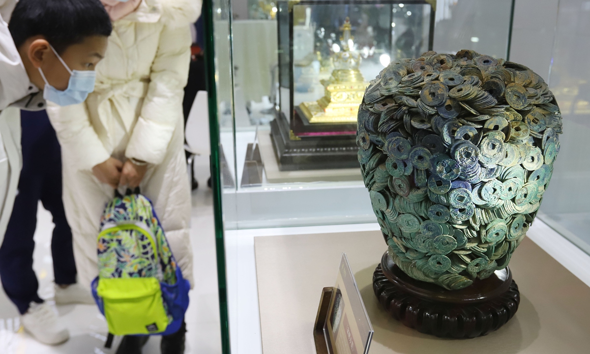Visitors attending the Beijing International Coin Exposition 2023 examine an exhibit on December 2, 2023. A total of 276 domestic and foreign exhibitors brought high-quality coins from various countries to the exhibition to show the development of the coin industry. Photo: cnsphoto