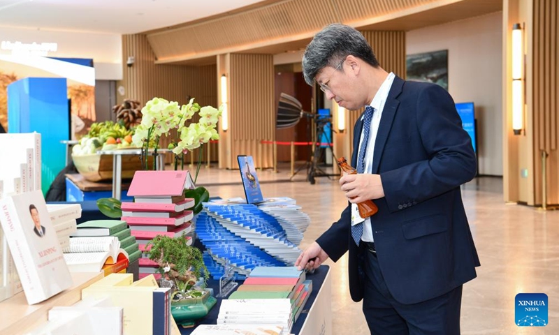 A guest flips through publications at the venue of the 5th World Media Summit in Nansha Bay Marina Convention Center in Guangzhou, south China's Guangdong Province, Dec. 2, 2023. (Photo: Xinhua)