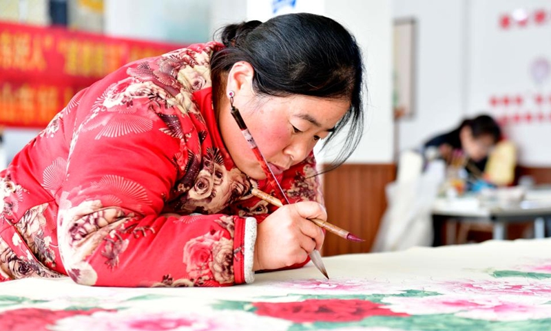 A farmer paints a peony-themed realistic painting at a studio in Juye County, Heze City of east China's Shandong Province, Dec. 2, 2023. Juye County is located in Heze, a city known for the cultivation of peonies. (Photo: Xinhua)