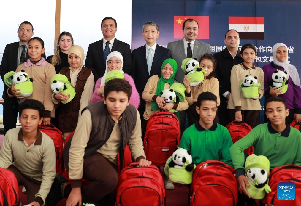 Chinese Ambassador to Egypt Liao Liqiang (4th L, back) , Secretary-General of Egypt's Homat Al Watan Party Tariq Naseer (3rd L, back) and other guests pose for a group photo with students during a donation ceremony held at the Al-Asmarat District's service center in the Cairo Governorate, Egypt, Dec. 5, 2023.(Photo: Xinhua)
