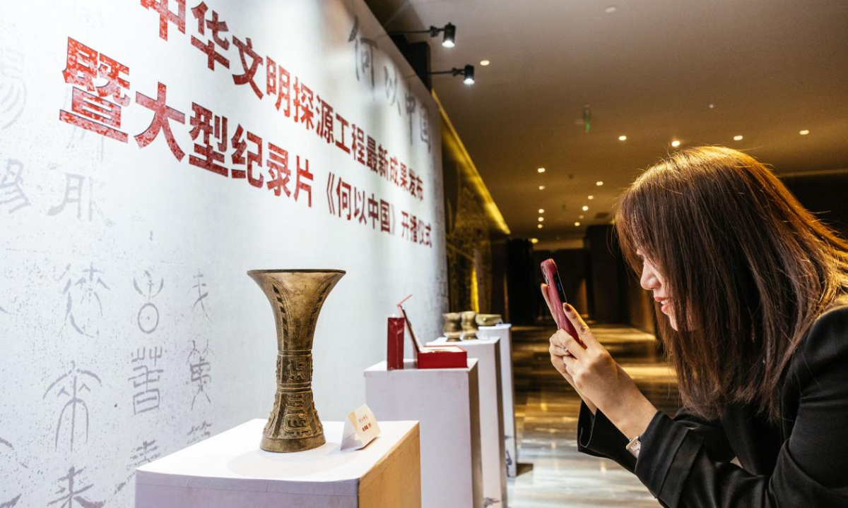 A visitor takes a photo of a copied artifact during a promotion event of documentary series China Before China in Beijing on Saturday. Photo: Li Hao/GT