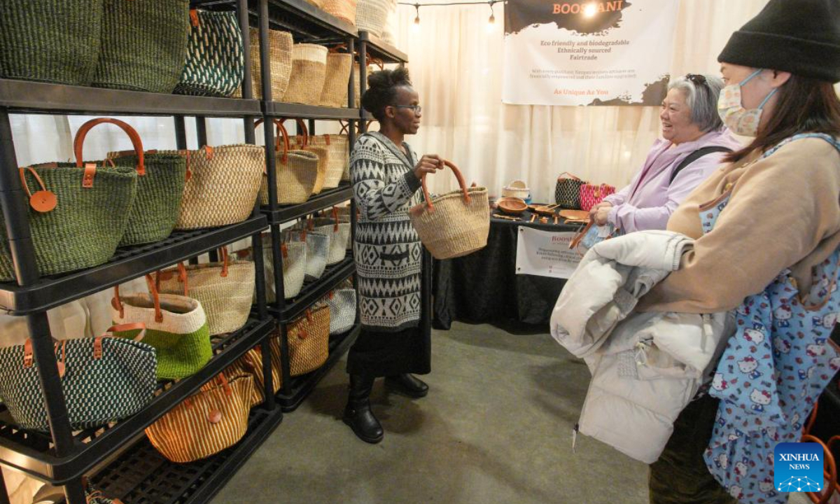 A vendor displays her handmade bag during the Make It show in Vancouver, British Columbia, Canada, Dec. 8, 2023. The trade event dedicated to handmade items features exhibitors from across Canada, offering a diverse range of handmade goods. Photo:Xinhua