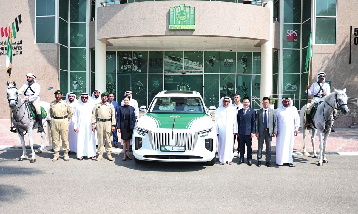 Dubai police officers and representatives from Oneroad Group Dubai pose with a Hongqi E-HS9 police car. Photo: Courtesy of Oneroad Group Dubai
