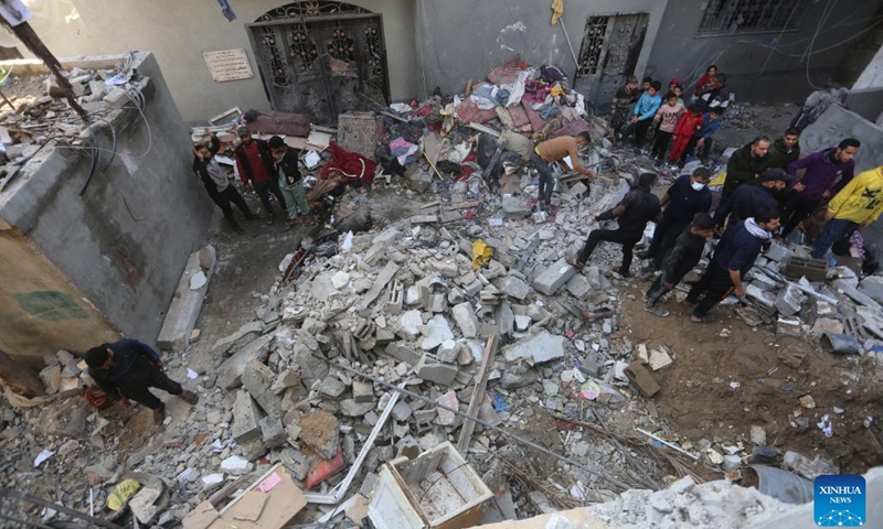 People are seen among the rubble of a building destroyed in an Israeli strike in the southern Gaza Strip city of Rafah, on Dec. 7, 2023. Since Oct. 7, Israel has been launching a large-scale attack against Hamas in Gaza under the name Iron Swords, which has left 17,177 Palestinians dead, and more than 46,000 injured, said the Gaza-based Health Ministry on Thursday.(Photo: Xinhua)