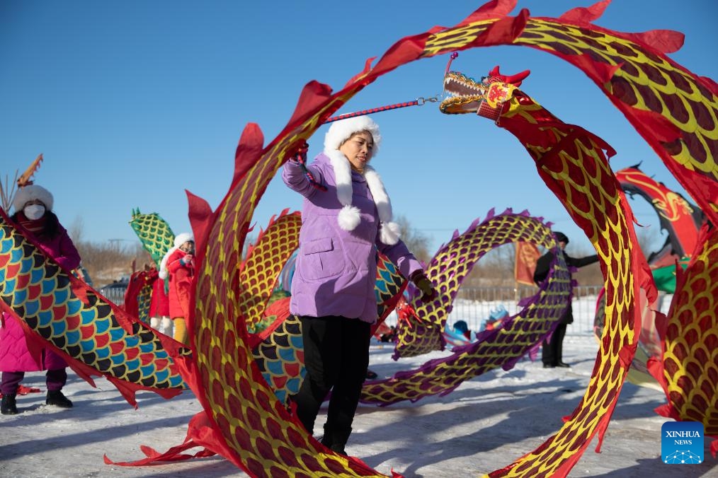 People play with ribbons during an ice collecting festival on the Songhua River in Harbin, capital of northeast China's Heilongjiang Province, Dec. 7, 2023. Ice cubes collected from the frozen Songhua River will be used in decoration of the city.(Photo: Xinhua)