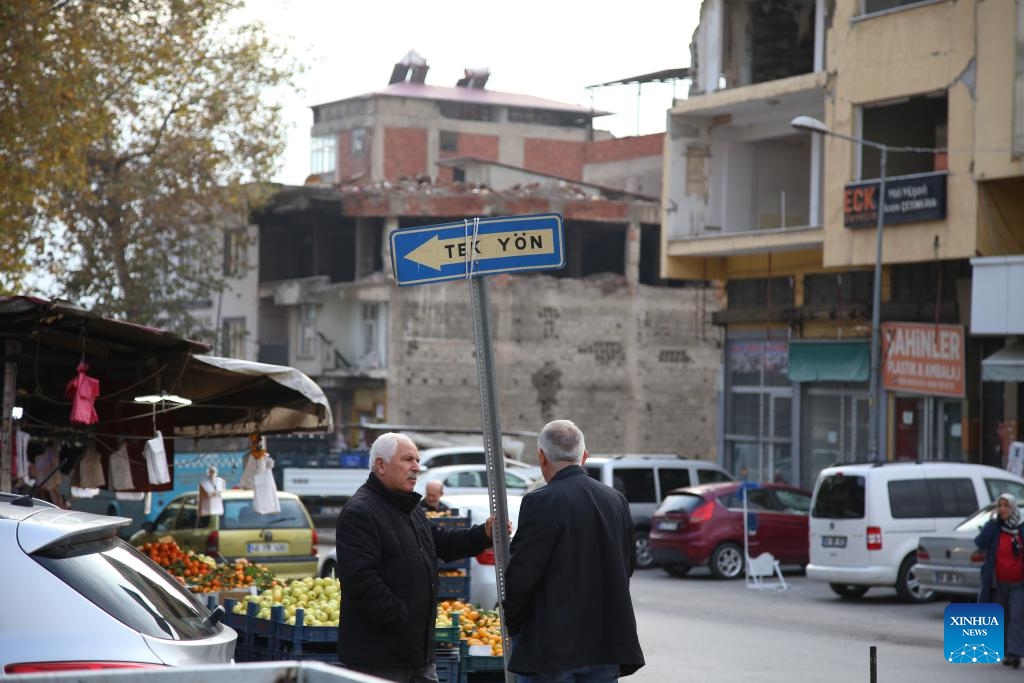 People talk on a roadside in Kahramanmaras, Türkiye, Dec. 6, 2023. Kahramanmaras was the worst-hit province and the epicenter of the massive earthquakes in February this year. The reconstruction work has been carried out and residents here have got their lives back on track.(Photo: Xinhua)