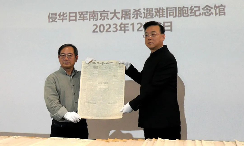 Lu Zhaoning (left) donates a US newspaper to the Memorial Hall of the Victims in Nanjing Massacre by 
Japanese Invaders. Photo: He Pengfei
