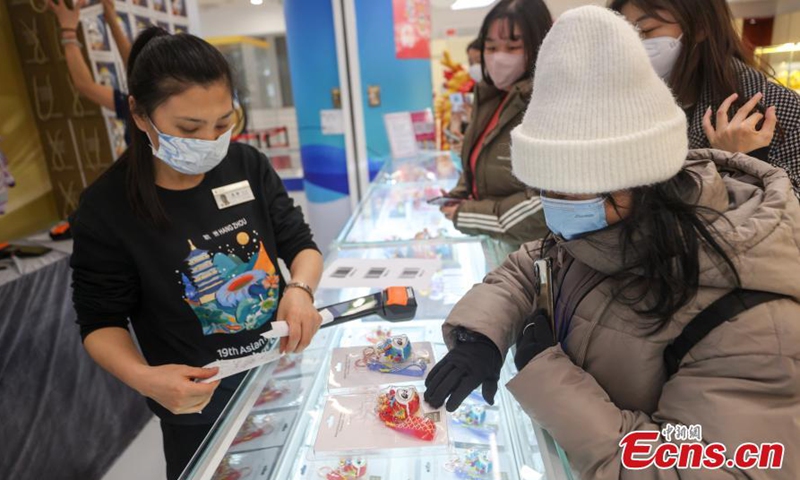 Customers select Chinese zodiac Dragon version of Bing Dwen Dwen, a Beijing Winter Olympic Games mascot, at a store in Beijing, Dec. 7, 2023. (Photo: China News Service)