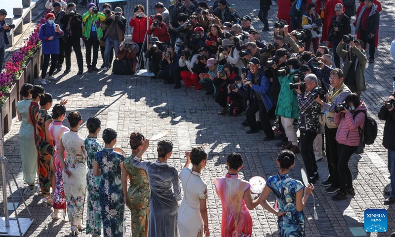 People take photos of a show featuring Qipao, a traditional Chinese dress for women, at a historical and cultural district along the Grand Canal in Wuxi, east China's Jiangsu Province, Dec. 8, 2023. (Photo: Xinhua)