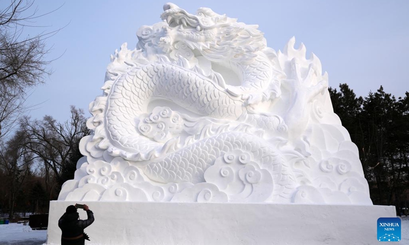 A sculptor takes a photo of a giant snow sculpture at the Sun Island scenic area in Harbin, northeast China's Heilongjiang Province, Dec. 12, 2023. With numerous snow sculptures constructed in the theme park titled snow world, the city of Harbin, known as China's ice city in the northeast, is witnessing the coming of its high season for tourism.(Photo: Xinhua)