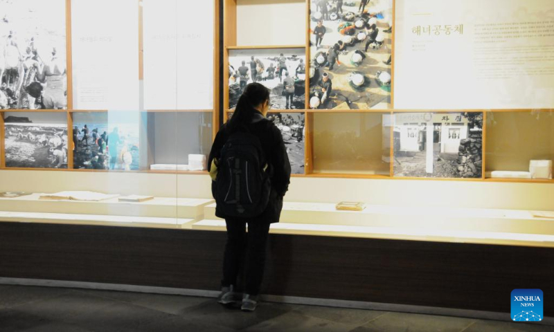 A tourist visits the Haenyeo museum in Jeju Island, South Korea, Dec. 15, 2023. Haenyeo refers to female divers who dive into the sea to gather various shellfish and seaweed without using any underwater diving equipment. The Culture of Jeju Haenyeo was inscribed in 2016 on the UNESCO Representative List of the Intangible Cultural Heritage of Humanity. (Photo by Yang Chang/Xinhua)