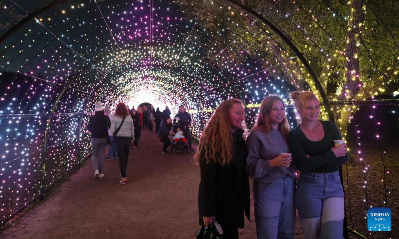 Visitors pose for a photo in a light tunnel at the Filoli Historic House & Garden in Woodside, California, the United States, Dec. 16, 2023. (Photo by Liu Yilin/Xinhua)