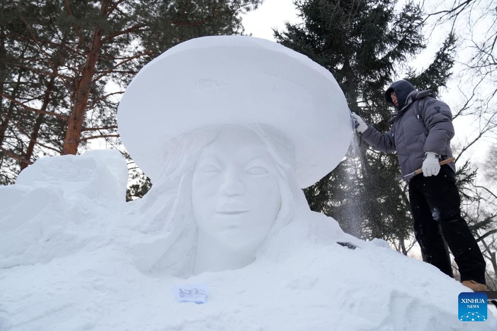 A sculptor works on a snow sculpture during a snow competition in Harbin, northeast China's Heilongjiang Province, Dec. 12, 2023. With numerous snow sculptures constructed in the theme park titled snow world, the city of Harbin, known as China's ice city in the northeast, is witnessing the coming of its high season for tourism.(Photo: Xinhua)