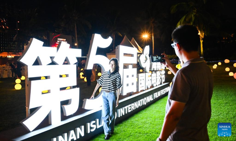 A woman poses for photos during the opening ceremony of the 5th Hainan Island International Film Festival in Sanya, south China's Hainan Province, Dec. 16, 2023. The festival runs from Dec. 16 to 22. (Xinhua/Fan Yuqing)