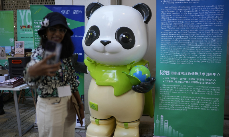 A person takes a selfie with a panda statue at the China Pavilion during the COP28 climate summit, on December 6, 2023, in Dubai, United Arab Emirates. Photo: VCG