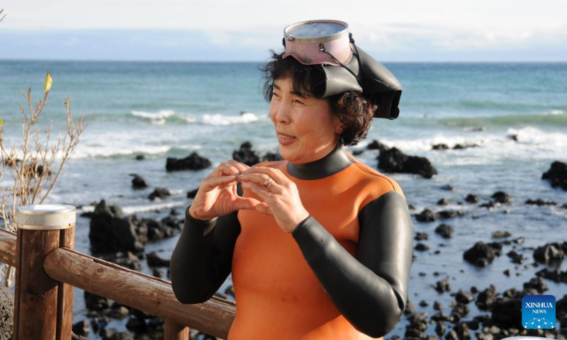 A Haenyeo poses for photos in Jeju Island, South Korea, Dec. 15, 2023. Haenyeo refers to female divers who dive into the sea to gather various shellfish and seaweed without using any underwater diving equipment. The Culture of Jeju Haenyeo was inscribed in 2016 on the UNESCO Representative List of the Intangible Cultural Heritage of Humanity. (Photo by Yang Chang/Xinhua)