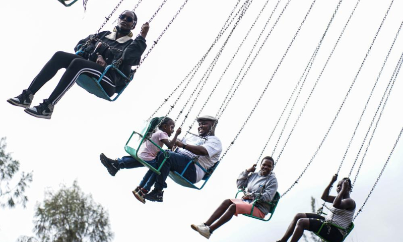 People enjoy a merry-go-round at Uhuru Park in Nairobi, capital of Kenya, on Dec. 16, 2023. (Xinhua/Li Yahui)