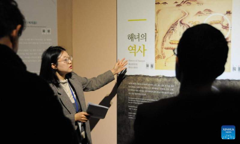 A tour guide introduces the history of Haenyeo at the Haenyeo museum in Jeju Island, South Korea, Dec. 15, 2023. Haenyeo refers to female divers who dive into the sea to gather various shellfish and seaweed without using any underwater diving equipment. The Culture of Jeju Haenyeo was inscribed in 2016 on the UNESCO Representative List of the Intangible Cultural Heritage of Humanity. (Photo by Yang Chang/Xinhua)