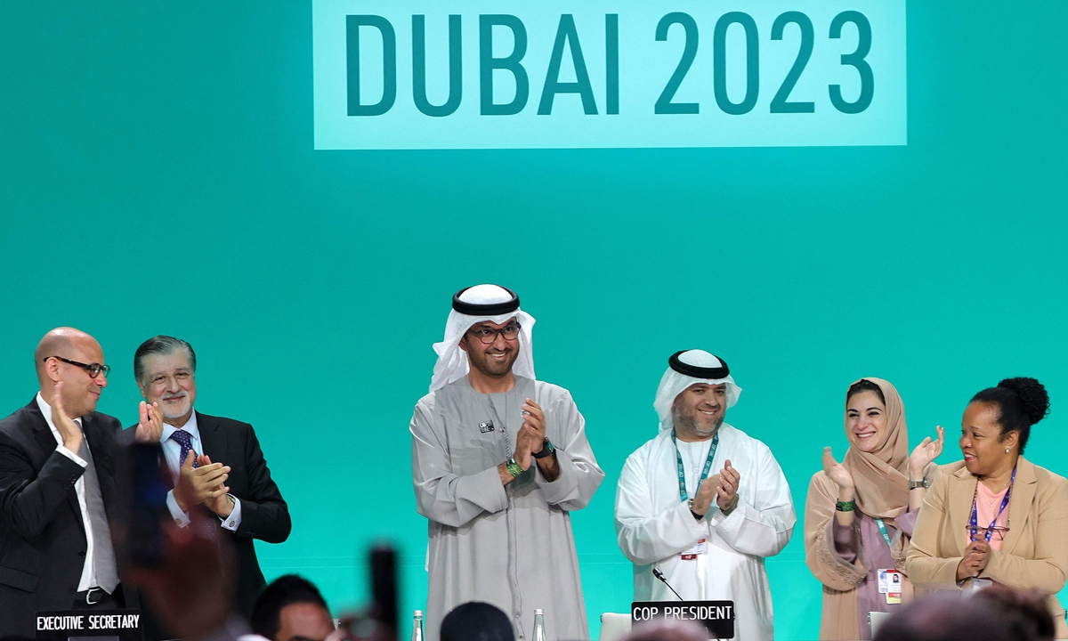 COP28 President Sultan Ahmed Al Jaber (center) applauds along with other officials before a plenary session during the United Nations climate summit in Dubai on December 13, 2023. Nations adopted the first ever UN climate deal that calls for the world to transition away from fossil fuels on the day. Photo: VCG