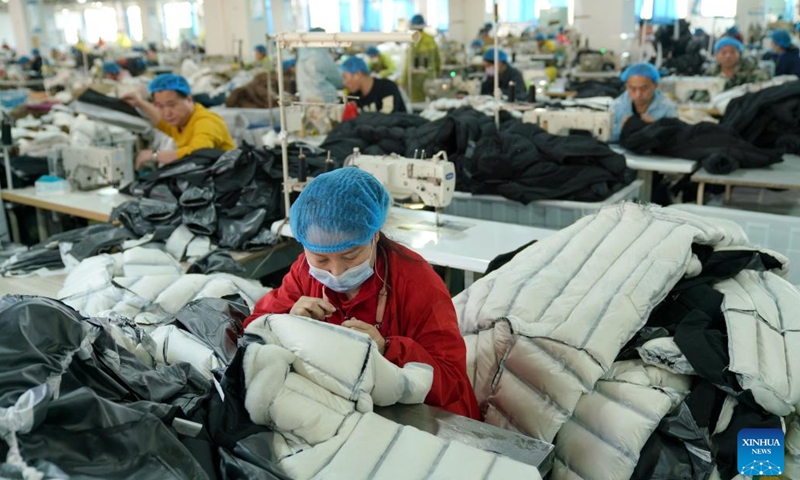 Workers make down garments at a clothing factory in Pinghu City, east China's Zhejiang Province, Dec. 14, 2023. Winter is the peak season for the down garment industry, which has gone through rapid development in Pinghu in recent years. In 2022, the down garment shipment volume of Pinghu was almost 200 million and the sales volume has exceeded 40 billion yuan (about 5.6 billion U.S. dollars).(Photo: Xinhua)