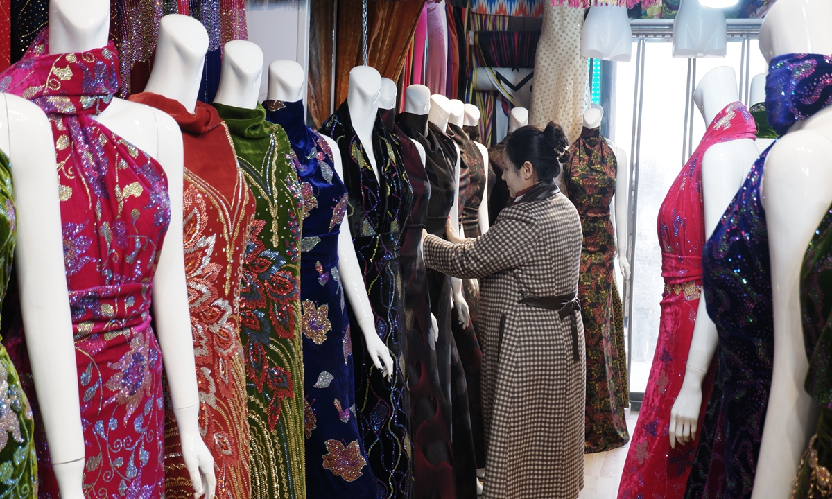 Zuregul Azrant at her silk shop with silk cloths of vibrant colors on display Photo: Xu Keyue/GT