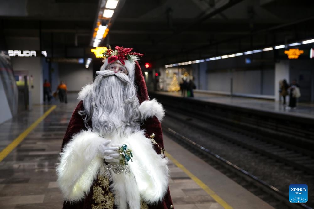 A man dressed in Santa Claus costume walks around receiving letters from children at a subway station in Mexico City, Mexico on Dec. 19, 2023.(Photo: Xinhua)