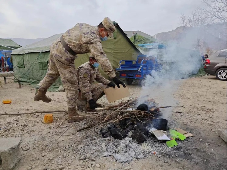 Rescuers help residents burn charcoal on December 20, 2023. Photo: People's Daily