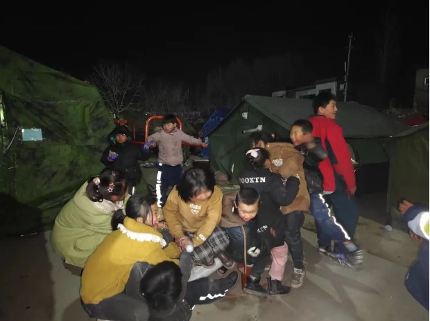 Children play outside the tents at night on December 20, 2023. Photo: People's Daily