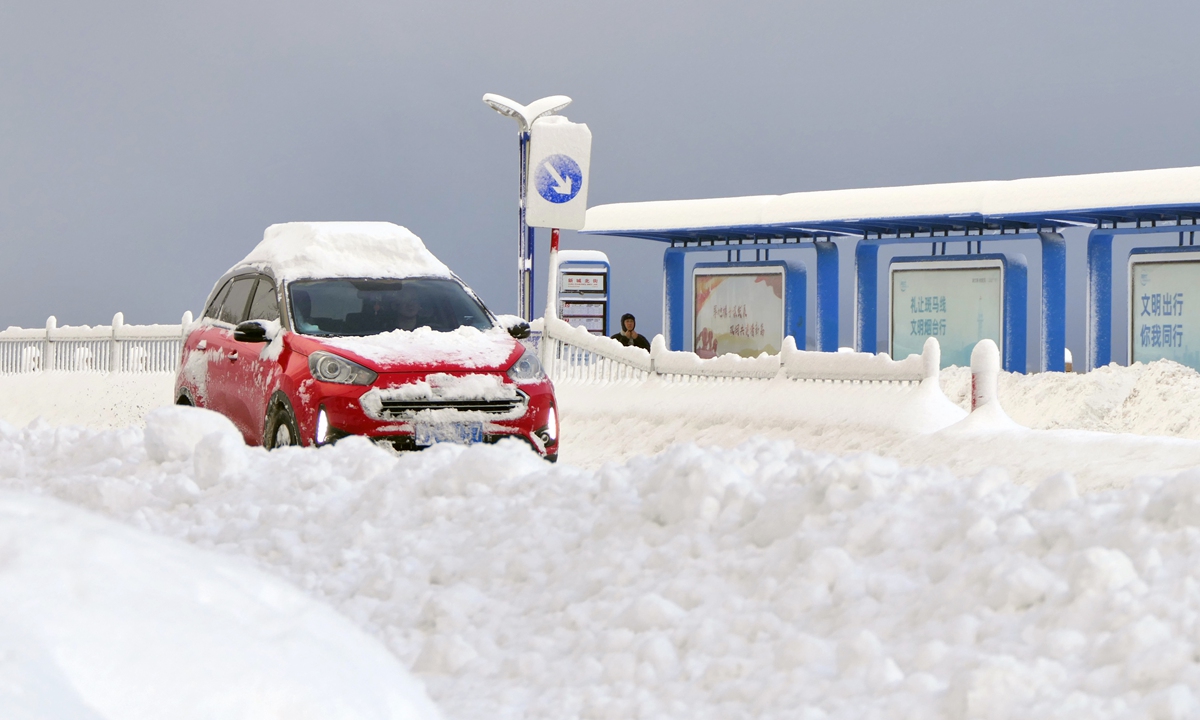 A car covered in snow makes its way down the road in Yantai, East China's Shandong Province, on December 21, 2023. According to local meteorological observatory, ?a maximum accumulated snow depth of 52 centimeter was recorded. The city is expected to see low temperature weather till December 24, with lows reaching -13 C in inland areas. Photo: VCG
