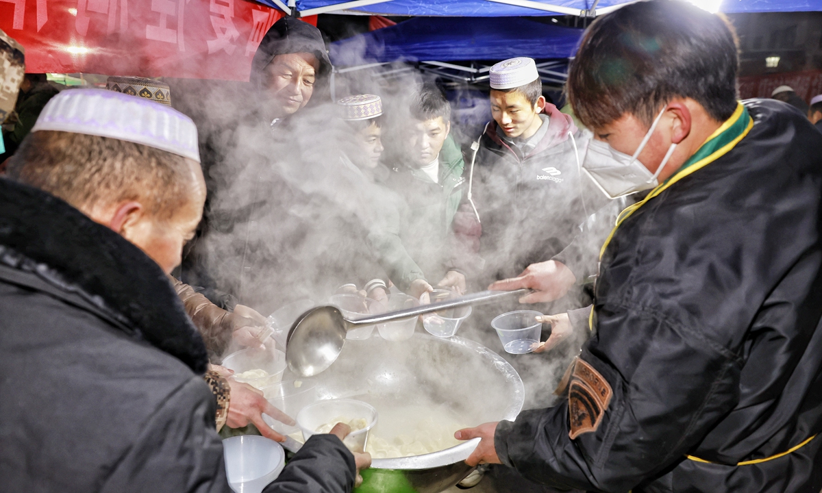Survivors share hot food to keep warm in a temporary earthquake shelter in Dahe village, Gansu, on December 19, 2023. Photo: Li Hao/GT