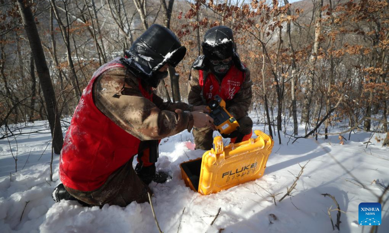 Staff members of local power supply company prepare their device to inspect the power line in Benxi, northeast China's Liaoning Province, Dec. 20, 2023. (Xinhua/Pan Yulong)