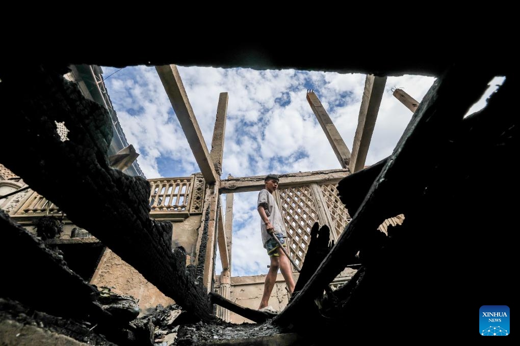 A resident is seen as he returns to the charred houses after a fire at a slum area in Manila, the Philippines, on Dec. 20, 2023.(Photo: Xinhua)