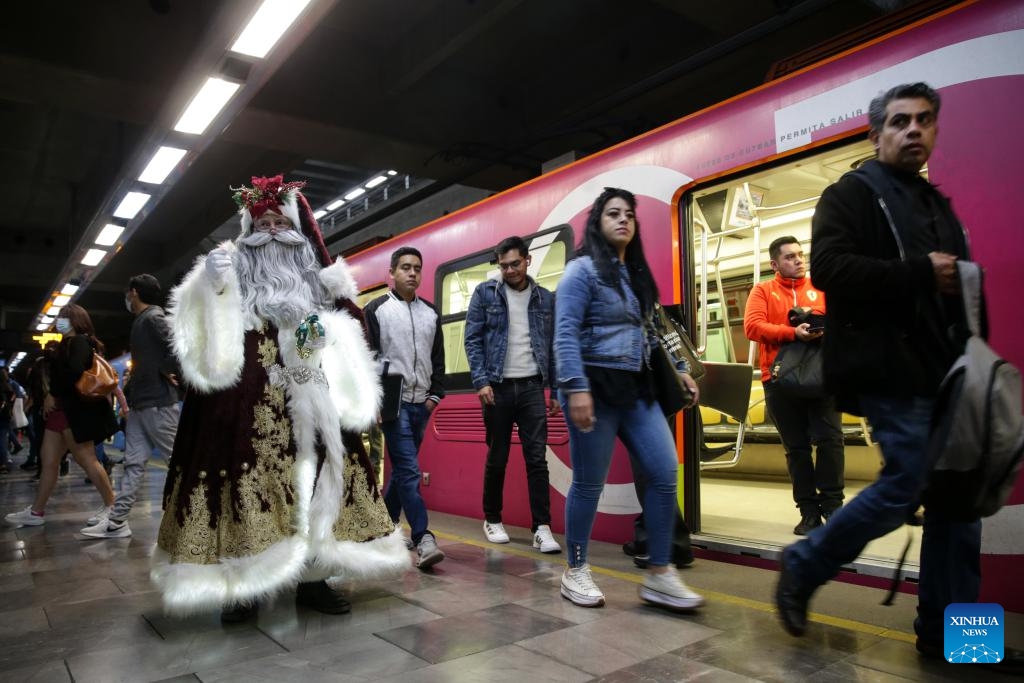 A man dressed in Santa Claus costume walks around receiving letters from children at a subway station in Mexico City, Mexico on Dec. 19, 2023.(Photo: Xinhua)