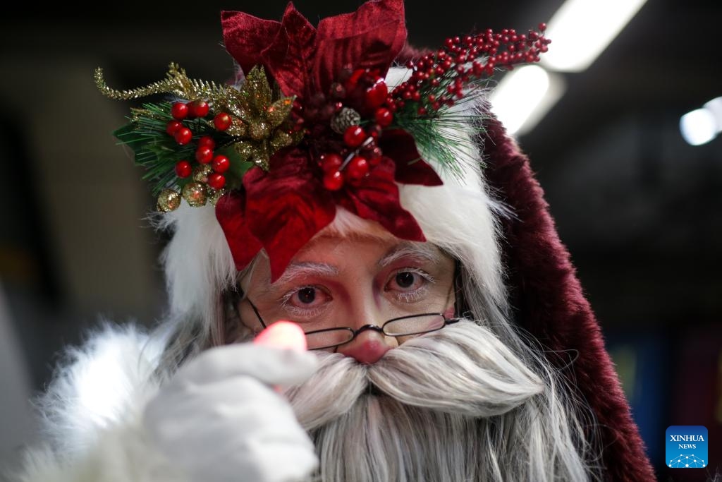 A man dressed in Santa Claus costume poses for a photo at a subway station in Mexico City, Mexico on Dec. 19, 2023.(Photo: Xinhua)