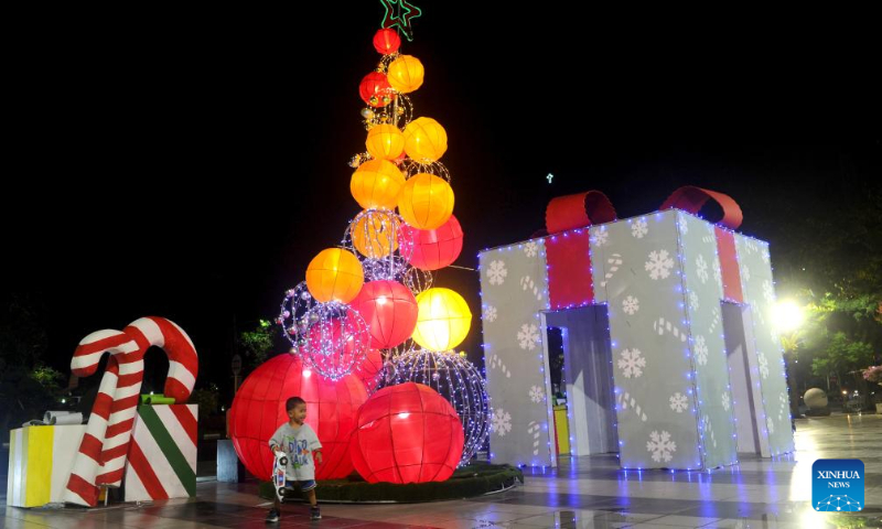 A boy has fun near Christmas light show installations in Surabaya, East Java, Indonesia, Dec. 23, 2023. (Photo by Sahlan Kurniawan/Xinhua)