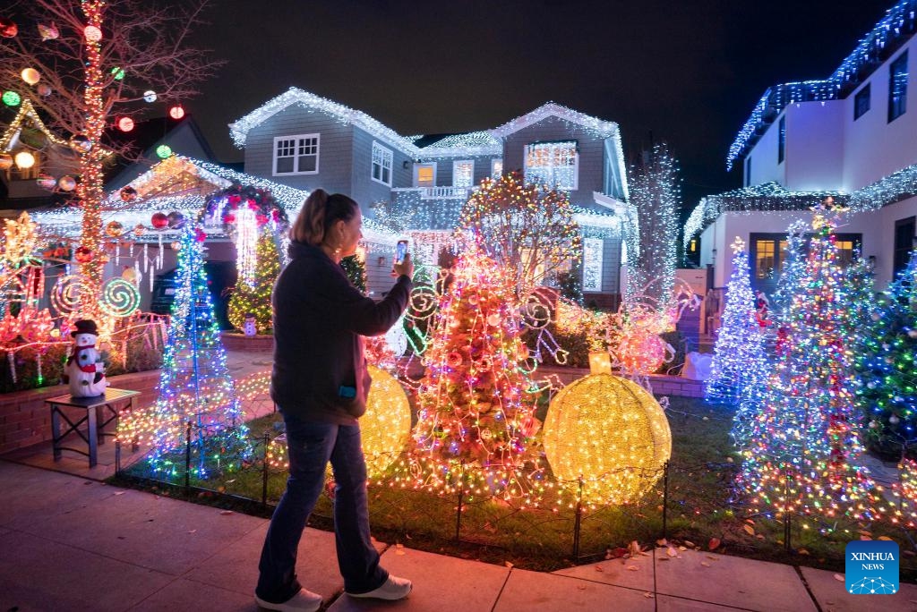 A woman watches Christmas decorations at a community in San Carlos, California, the United States, Dec. 19, 2023.(Photo: Xinhua)