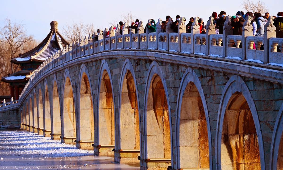 People take photos on the 17-Arch Bridge in the Summer Palace in Beijing, China, on December 22, 2023. The day also marks Dongzhi, or Winter Solstice on the Chinese lunar calendar, which is the best time of year to view the setting sun illuminating the bridge's arches. Photo: IC