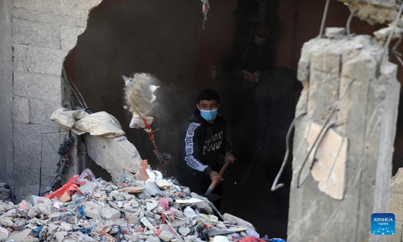 People clean up the rubble after an Israeli airstrike in the southern Gaza Strip city of Rafah, Dec. 24, 2023. At least 166 Palestinians were killed and 384 others were wounded during the past 24 hours by the ongoing Israeli attacks on the Gaza Strip, said the Gaza-based Health Ministry on Sunday. (Photo by Yasser Qudih/Xinhua)