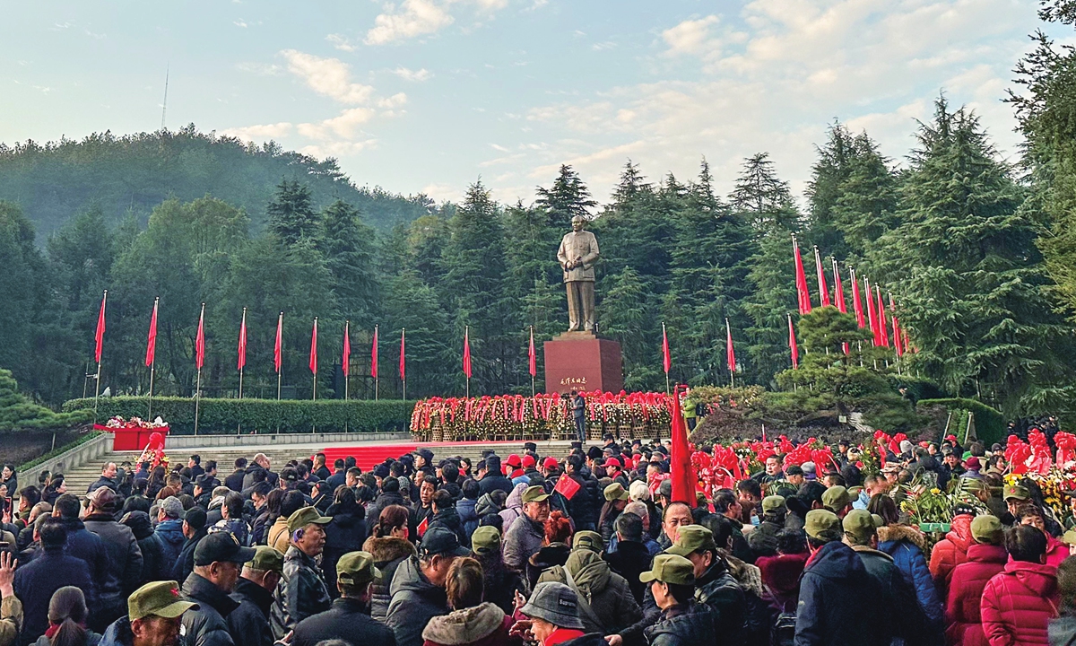 Les gens se rassemblent sur la place Mao Zedong à Shaoshan, la ville natale du défunt dirigeant dans la province du Hunan, dans le centre de la Chine, déposant des fleurs devant une statue géante de Mao et chantant la chanson révolutionnaire 
